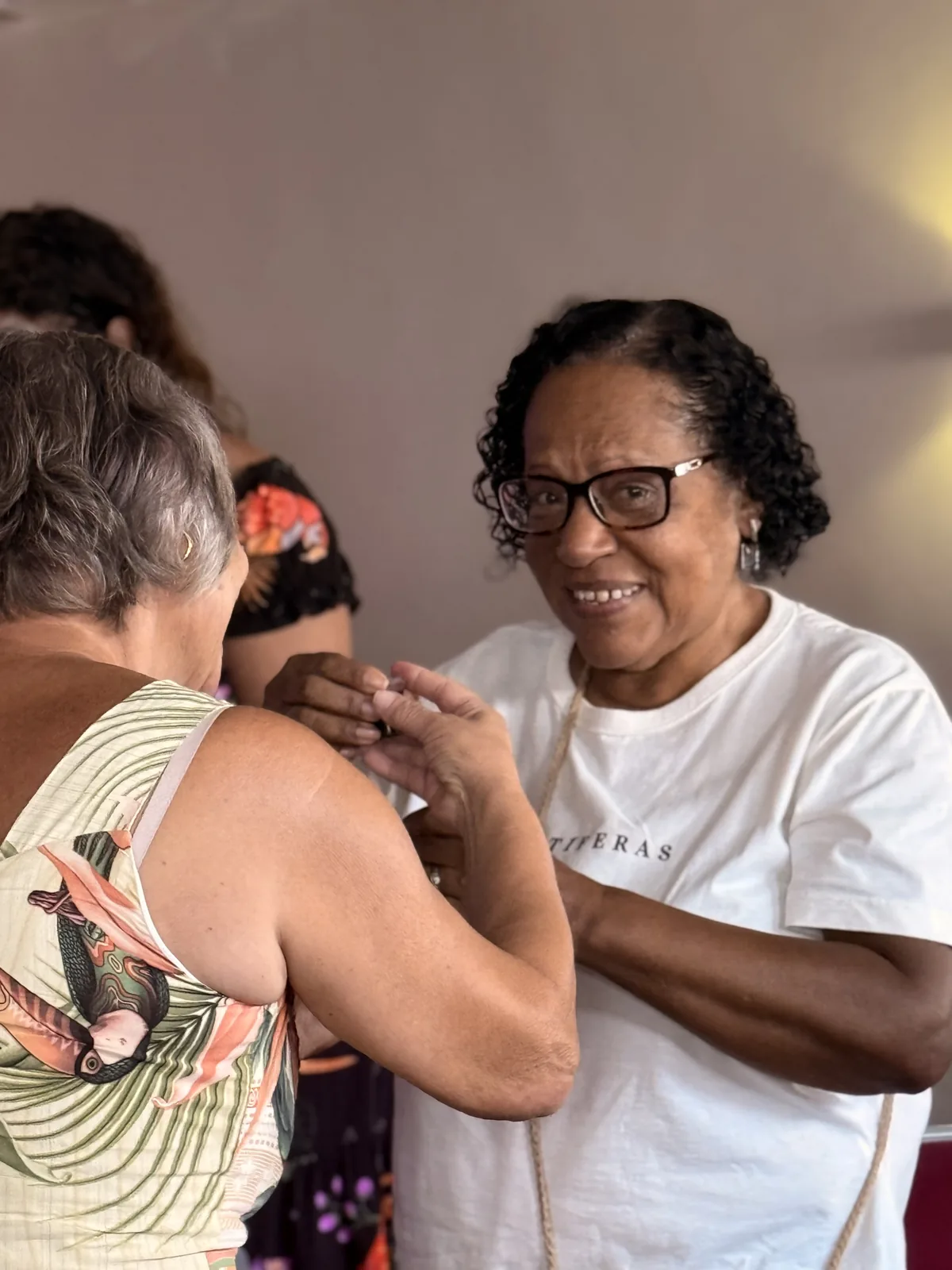 Duas irmãs de mãos dadas se cumprimentando com um sorriso