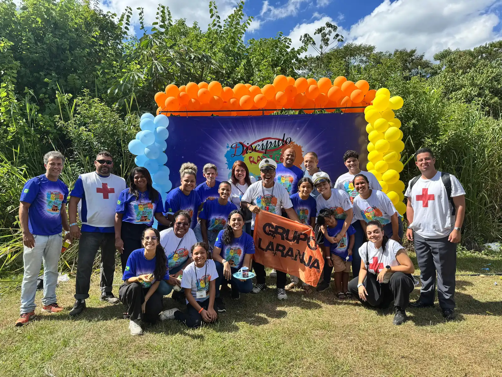 Equipe do Discípulo Radical Júnior com balões coloridos e a faixa do Grupo Laranja